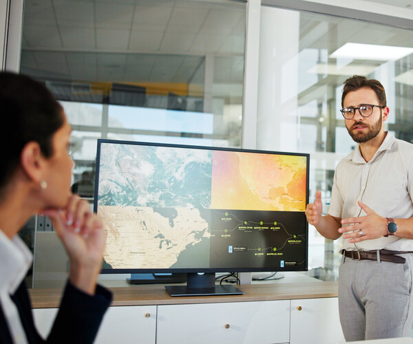 Businessman, screen or meeting with discussion for climate change, renewable energy or development at office. Man, employee or speaker with geographic data or technology display for global project